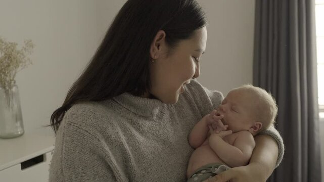 Baby, mom and rock to sleep with love, hug and quality time bonding together for relationship in home. Mother, talking and infant sleeping in arms of mommy, motherhood or care for newborn in bedroom