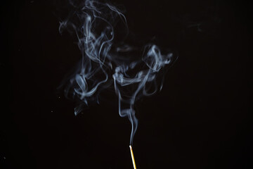 Abstract pattern of smoke of incense stick against black background. Photo taken February 8th, 2025, Zurich, Switzerland.