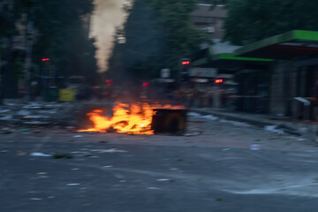 A fire is burning in a dumpster on a street