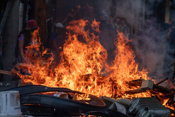 A fire is burning in a pile of tires and debris