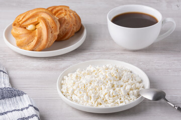Light breakfast with coffee, creamy cottage cheese, and sweet pastries on wooden table