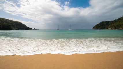 Exotic tropical beach dazzles with lush hills and crystal waters in Tobago, Trinidad and Tobago. Caribbean exotic and beaches beauty. For nature editorials, cosmetic branding, inspirational designs.