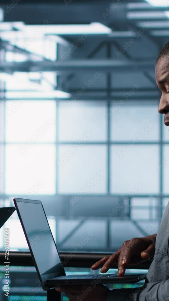 Poster vertical video smiling admins using laptop in data center, managing server virtualization. cheerful 