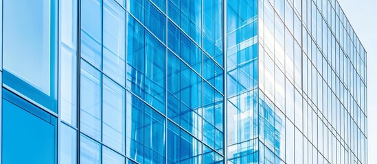 Obraz premium Modern office building exterior with reflective glass windows showcasing architectural design and urban landscape in clear blue sky