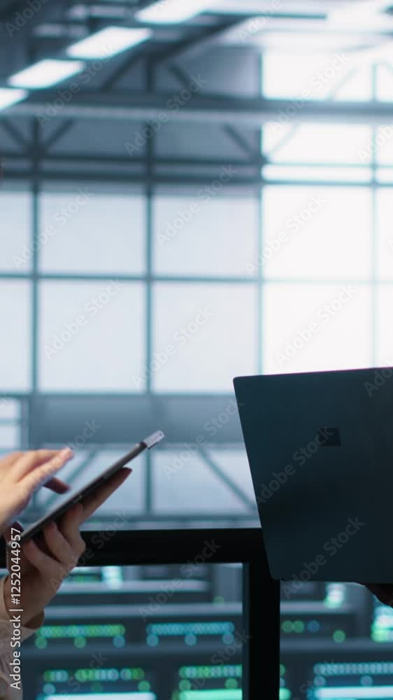 Poster vertical video system administrators using notebook device in data center, managing server virtualiz