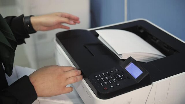 Person loading paper into a printer