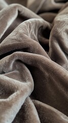 Soft and cozy gray fabric draped and folded on a soft surface