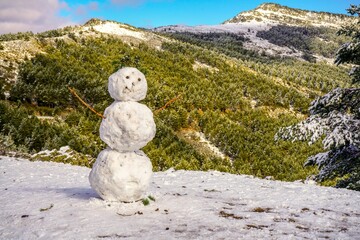 Muñeco de nieve en una montaña nevada.