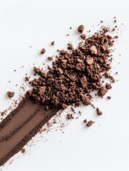Crumbled cocoa powder arranged on a clean white surface in an artistic display