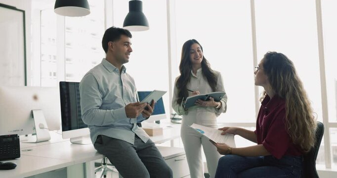 Group of employees, department workers engaged in collaborative discussion, brainstorming ideas for project or presentation, reviewing and analyzing reports data, planning upcoming meetings or events