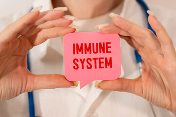 On a light background there is a pen and a sheet of paper with the text IMMUNE SYSTEM.
