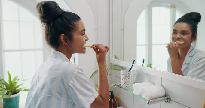 Brushing teeth, morning and mirror with woman in bathroom for self care, oral hygiene and dental. Cleaning, wellness and fresh breath with person at home for toothbrush, healthy gums and smile