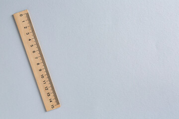 One wooden ruler on light grey background, top view. Space for text