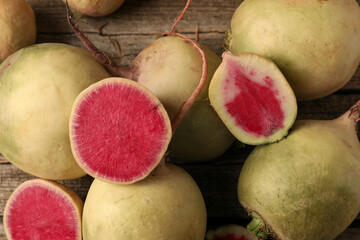 Whole and cut fresh turnips on wooden table, closeup