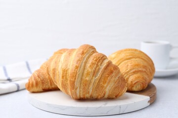 Tasty fresh croissants on light table, closeup