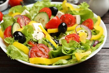 Delicious fresh Greek salad on wooden table, closeup