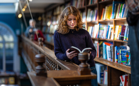 Teenage girl reading the book in the Marylebone bookstore in London, England
