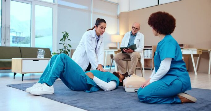 Doctor, teacher or students with CPR for nursing course, training or practice at hospital. Medical mentor, trainer or surgeon with junior intern for emergency, first aid or healthcare lesson on floor
