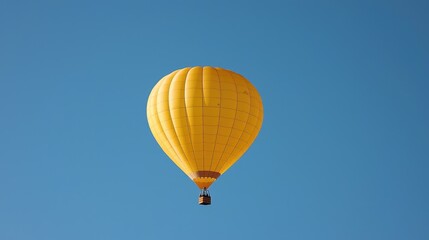 Fototapeta premium Yellow hot air balloon floats in clear blue sky. Travel, tourism, adventure