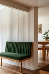Stylish interior design featuring a green upholstered bench and wooden dining table in a modern minimalist space with natural light during the day