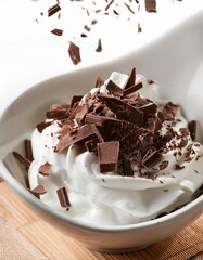 Shaving Dark Chocolate Over a Bowl of Whipped Cream