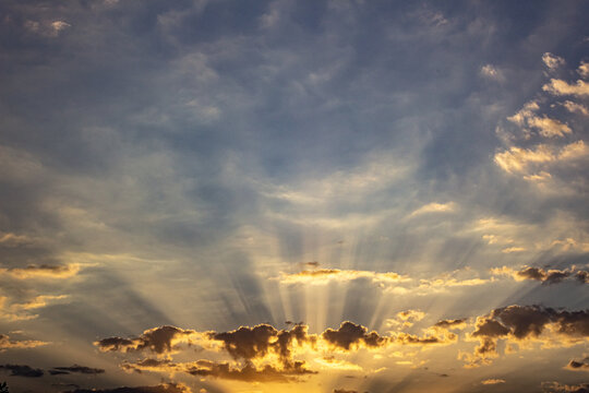 Sunset sky with clouds and sunbeams. Nature background.