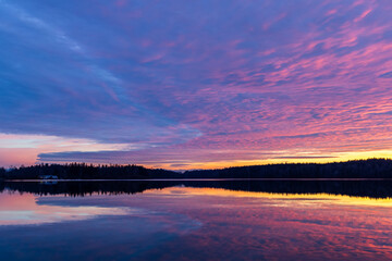 Stunning Vibrant Sunset Over Pristine Lake With Reflection and Forest Silhouette