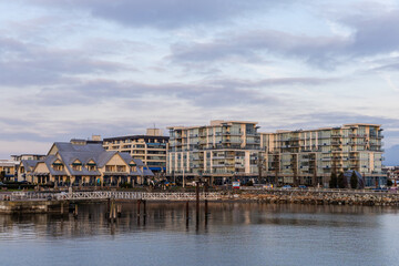 Modern Waterfront Buildings with Pier Under Cloudy Sky