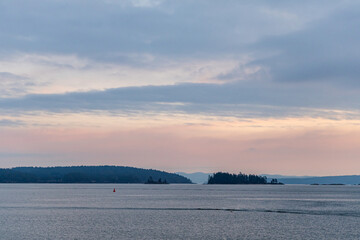 Serene Evening View of a Coastal Landscape with Calm Water and Distant Islands