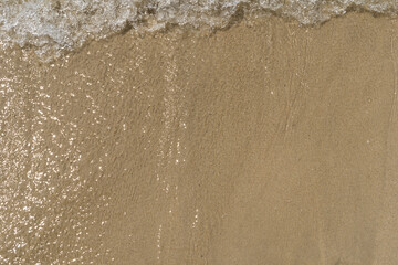 Summer waves crash on the sandy beach