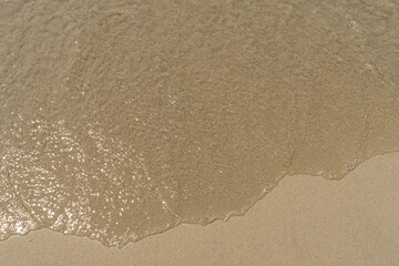 Summer waves crash on the sandy beach