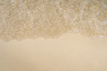 Summer waves crash on the sandy beach