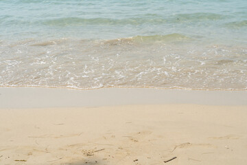 Summer waves crash on the sandy beach