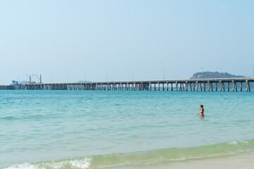 A young woman enjoys a relaxing summer vacation by the blue water of a tropical beach or pool