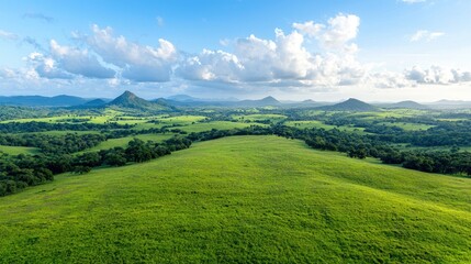 Fototapeta premium Panoramic view of rolling hills and lush green valleys under a partly cloudy sky. Possible use nature photography, travel brochure, tourism marketing
