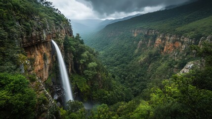 Waterfall cascades down cliff, lush valley, dramatic sky, nature tourism