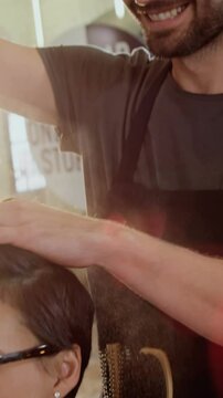 Male hairdresser styling customers hair