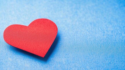 Fototapeta premium Vibrant Red Heart Shape on Soft Blue Background for Romantic Themes