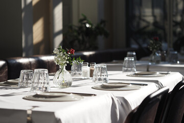 Elegant dining setup at a restaurant with natural sunlight