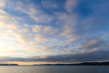 Scenic Sunset Over Calm Waters and Clouded Sky in Coastal Environment