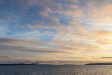 Beautiful Sunset Over Calm Ocean With Cloudy Sky and Distant Islands