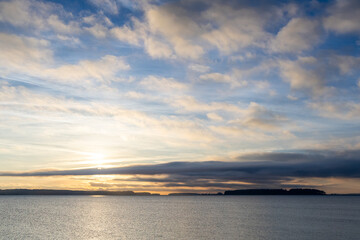 Obraz premium Scenic Sunrise Over Calm Ocean with Stunning Cloudscape Views