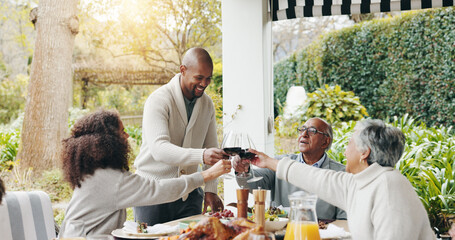 Family, toast and outdoor dining table for celebration on vacation, easter lunch and proud to connect. Old people, cheers and share traditional holiday in garden, social gathering and patio party