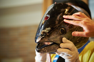 Hand holding a tuna head