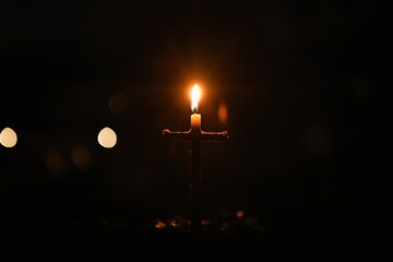 burning candle cross in the dark, symbolizing hope and quiet reflection on Easter 