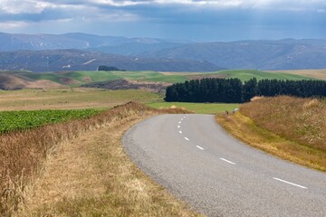 Empty country road winds through rolling hills. Scenic rural landscape. Perfect for travel or nature photography. , Napier Taihape Road, Manawatu-Whanganui, New Zealand