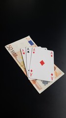 Three aces lying next to the Euro banknote
