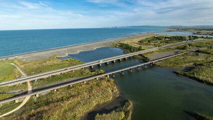 Aerial view of multiple bridges crossing a waterway, connecting the ocean to a bay. Coastal landscape. Clive, Napier, Hawke's Bay, New Zealand
