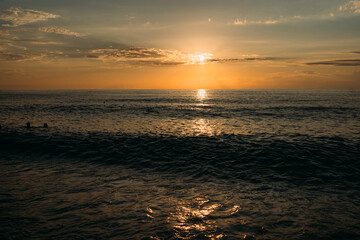 Powerful ocean waves crashing on the shore at sunset