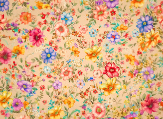Delicate floral pattern featuring a variety of vibrant blossoms in shades of pink, blue, yellow, orange, and purple, scattered across a soft, neutral backdrop.